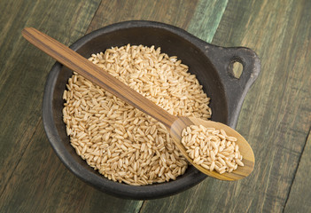 Grain oats in bowl and wooden spoon.