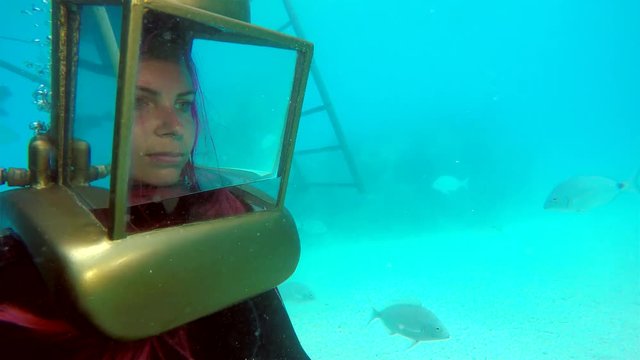 Girl in the helmet looks at sea creatures at the Bermuda Helmet Diving tour. 