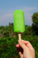 Ice cream in hand on the blue sky