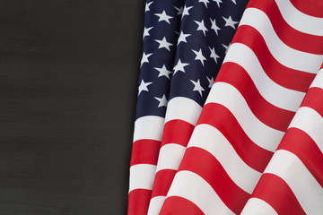 Beautifully folded USA flag on black chalkboard with copy space.