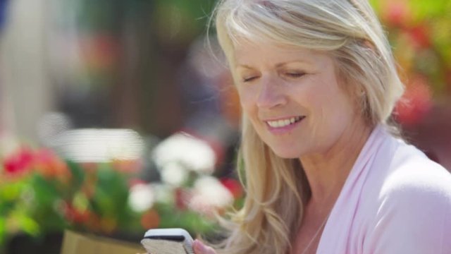  Portrait of beautiful mature woman looking at mobile phone outdoors in city