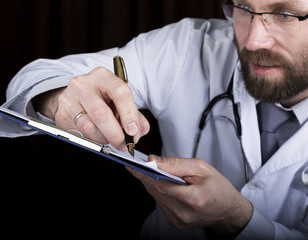 close-up hands of a medical doctor, the doctor signs a handle documents. Doctor writes medical history. write a prescription patient data history