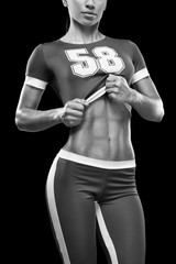 Fitness athletic young woman showing her well trained body, six pack, perfect abs, shoulders,...