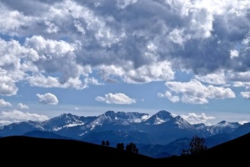 Sky, Clouds, Snow Capped Mountains, Silhouettes of Hills and Trees. North Cascades National Park, Winthrop, WA, USA