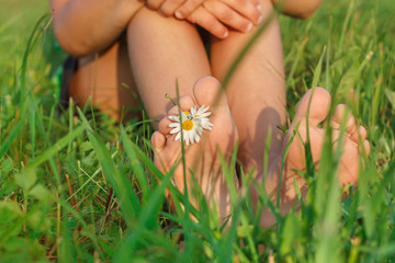 Children's feet on the green grass .People having fun outdoors in spring park