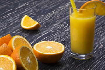 Orange juice in glass,  fresh fruits on wooden background