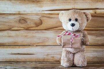 Teddy bear holding a gift box