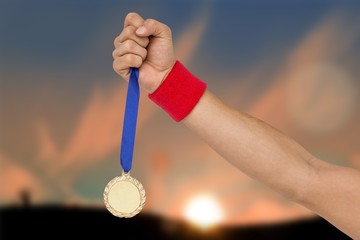 Naklejka na ściany i meble Composite image of athlete holding gold medal after victory