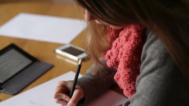 young woman in an office hands writing on paper