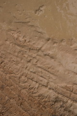 Vertical overhead CU muddy jungle road featuring very soft frothy mud