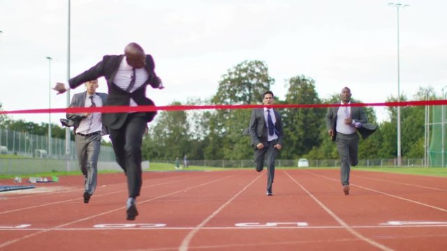  Group of competitive businessmen racing to the finish line at running track