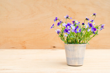 Spring flowers in vintage vase on wooden background, rustic style.