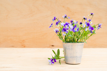 Spring flowers in vintage vase on wooden background, rustic style.
