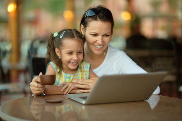 woman with girl using laptop