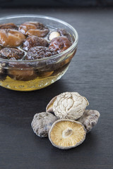 Dried Chinese mushroom in water on black wooden background.