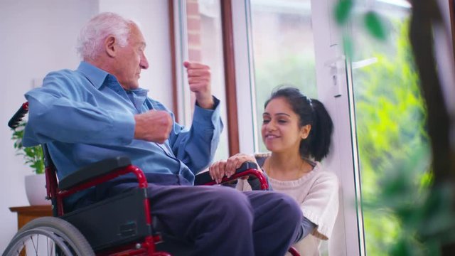  Caring young home support worker with elderly gentleman in his home