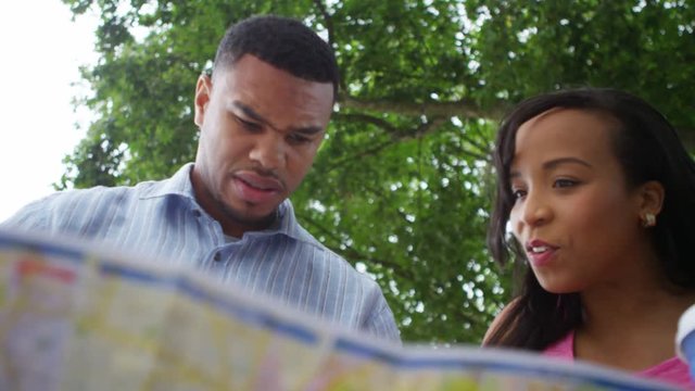  African American couple lost in London, looking at map for directions. 