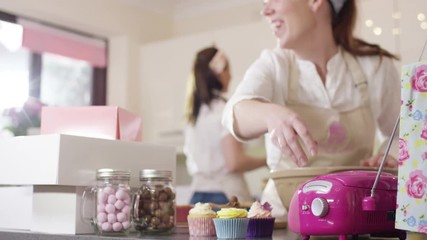  Female business partners in home bake business dancing to music on the radio