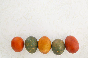 Easter eggs colored with natural onion and cabbage dye on marble background