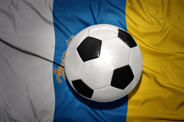 Naklejka premium black and white football ball on the national flag of canary islands