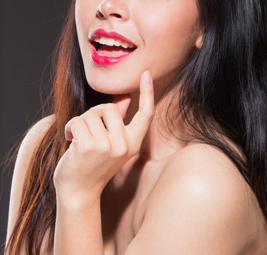 Portrait of beautiful young woman with naked shoulders,on black background,Focus on mouth. 