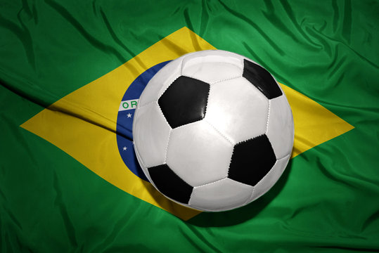 black and white football ball on the national flag of brazil