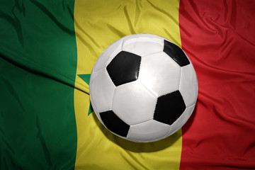 Naklejka premium black and white football ball on the national flag of senegal
