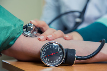 healthcare, hospital medicine concept - doctor and patient measuring blood pressure