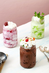 gelato con cioccolato e frutta mista in vasetti di vetro su tavolo 