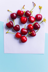 Obraz na płótnie Canvas group of cherries on envelope, in a contemporary pastel color background