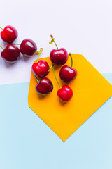 group of cherries on envelope, in a contemporary pastel color background