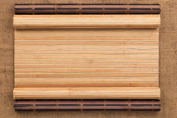 Two bamboo mat twisted in the form of a manuscript on sackcloth