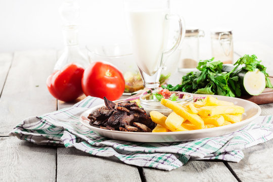 Grilled meat with French fries and fresh vegetables