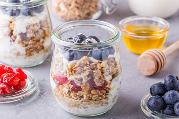 Healthy breakfast - glass jars of oat flakes with  fruit, yogurt.