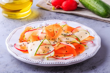 Vegetarian salad of carrot, cucumber and radish.