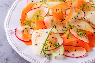 Vegetarian salad of carrot, cucumber and radish.