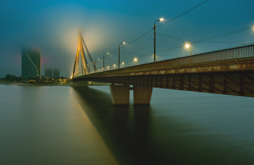 Obraz na płótnie Canvas Cable bridge through the Daugava river in center of Riga - the capital and largest city of Latvia, a major commercial, cultural, historical and financial center of the Baltic region