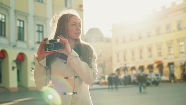 young female taking pictures of a city with an old camera slow motion