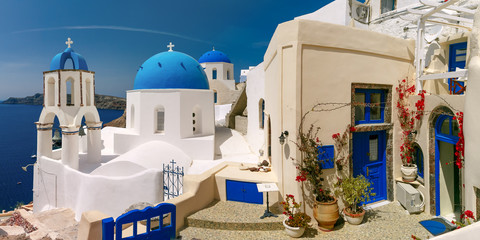 Picturesque view of white houses and church with blue domes in Oia or Ia, island Santorini, Greece