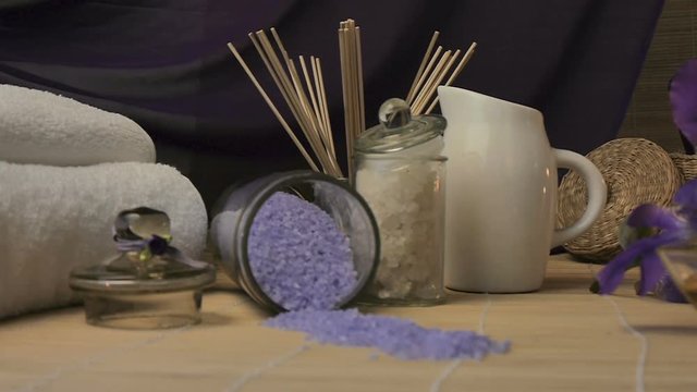 Close-up. Spa Still Life. Sea Salt Bath, Massage Oil, Candles, Flowers Fnd Towels. In Move