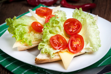 Delicious sandwich with tomatoes, cheese and lettuce.