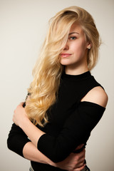 Fototapeta premium Beautiful young woman with gorgeous hairstyle posing over white