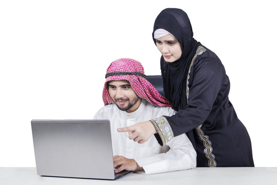 Arabian couple working with laptop