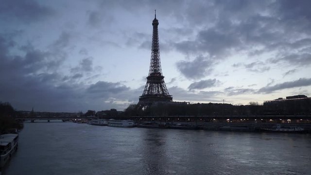 Eiffel Tower and Seine River in twilight just before sunrise with fast passing clouds. Paris, Port de Suffren, Grenelle, 7th Arrondissement. France