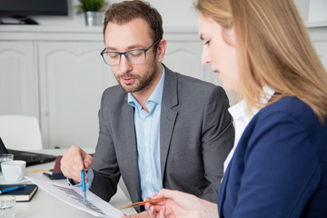 Male and female business colleagues discussing about business chart   