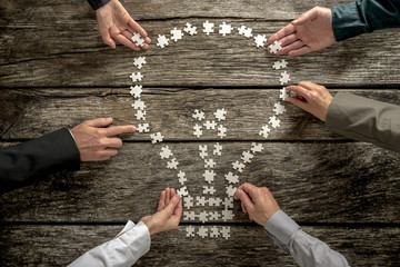 Top view of six business people, male and female, assembling a l