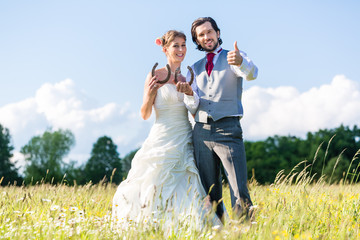 Hochzeit Braut und Bräutigam zeigen Hufeisen für Glück 