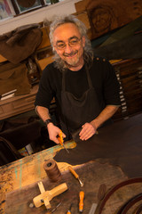 Leather goods craftsman at work in his workshop
