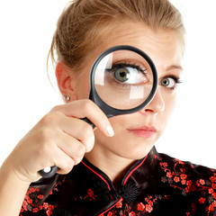 Woman looking through a magnifying glass