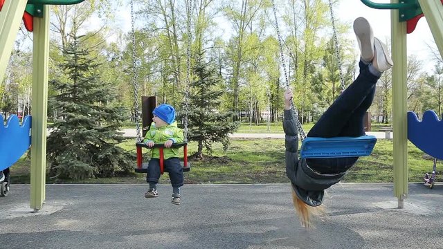 Mother and baby ride on a swing